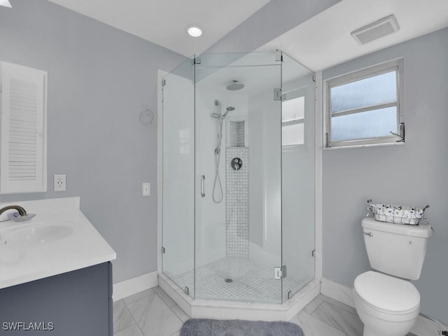 bathroom featuring vanity, a shower with shower door, and toilet