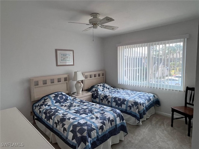 carpeted bedroom with a ceiling fan and baseboards