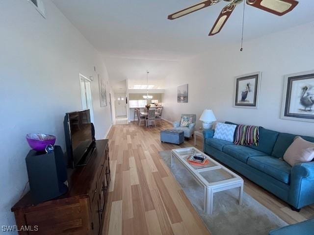 living room featuring light wood-type flooring, lofted ceiling, and a ceiling fan