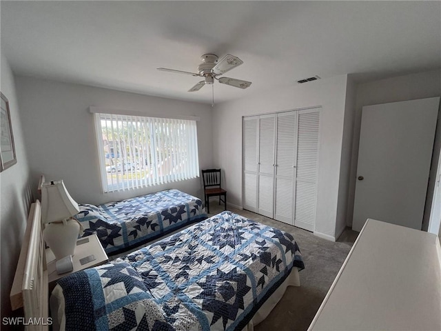 bedroom with carpet flooring, visible vents, baseboards, a ceiling fan, and a closet