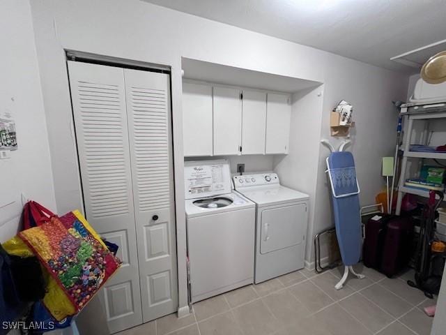 laundry room with cabinet space, washer and dryer, and light tile patterned flooring