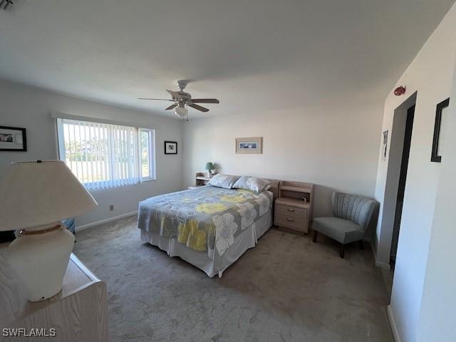 bedroom with a ceiling fan, light colored carpet, and baseboards