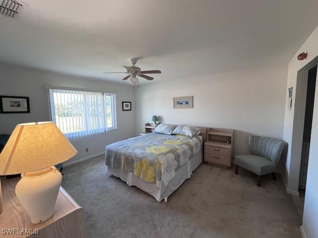 carpeted bedroom with baseboards, visible vents, and a ceiling fan