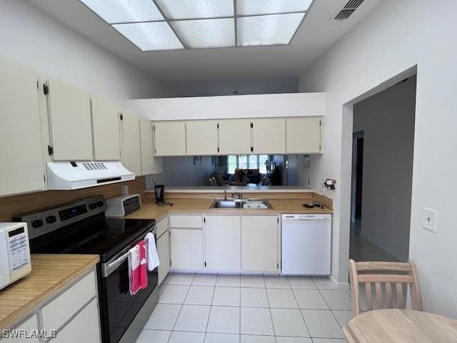 kitchen with light tile patterned floors, light countertops, visible vents, white appliances, and extractor fan