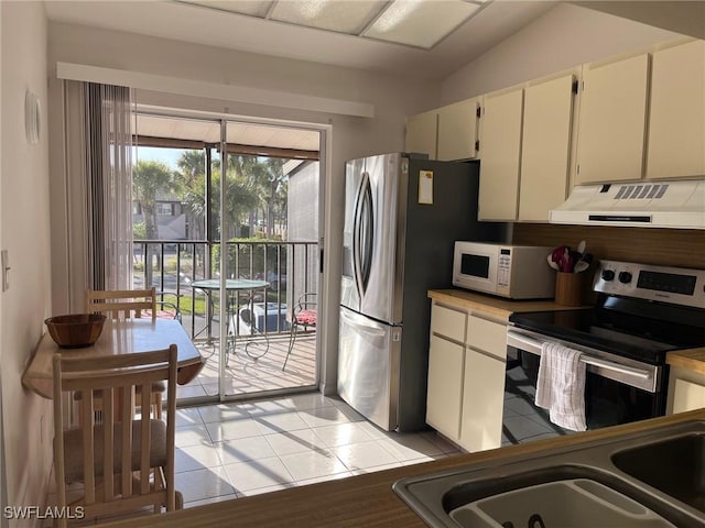 kitchen featuring light tile patterned floors, under cabinet range hood, a sink, white cabinets, and appliances with stainless steel finishes