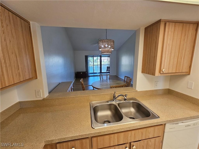 kitchen with pendant lighting, white dishwasher, sink, kitchen peninsula, and a chandelier