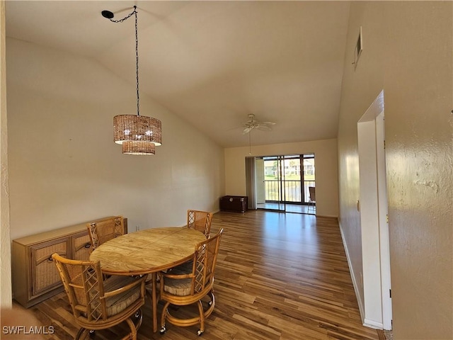 dining area with dark hardwood / wood-style flooring, high vaulted ceiling, and ceiling fan with notable chandelier