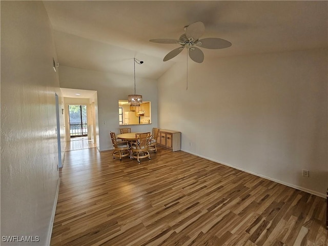 dining space featuring ceiling fan, dark wood-type flooring, and lofted ceiling