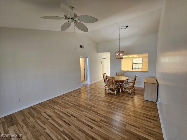 dining area with ceiling fan, hardwood / wood-style floors, and high vaulted ceiling