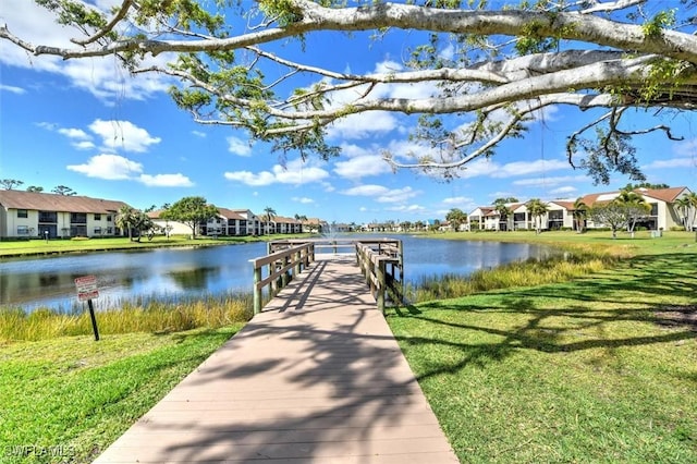 dock area featuring a lawn and a water view