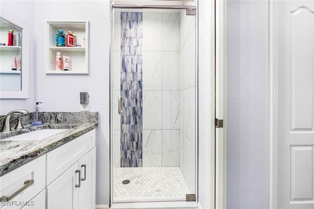 bathroom featuring a tile shower and vanity