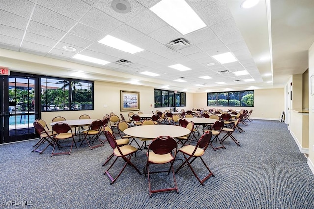 dining room featuring a paneled ceiling and dark carpet