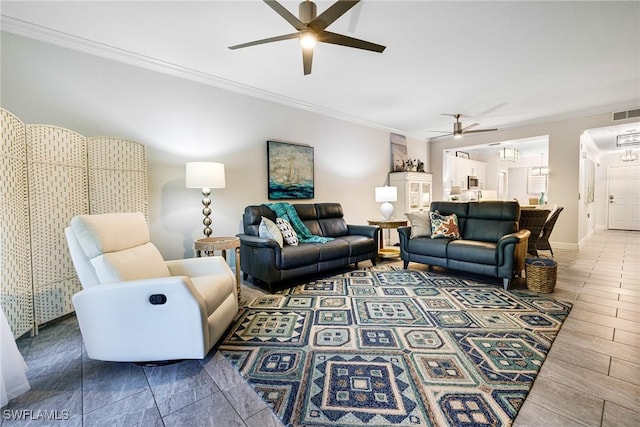 living room with ceiling fan and ornamental molding