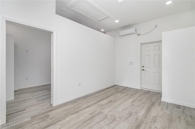 empty room featuring light hardwood / wood-style floors and an AC wall unit