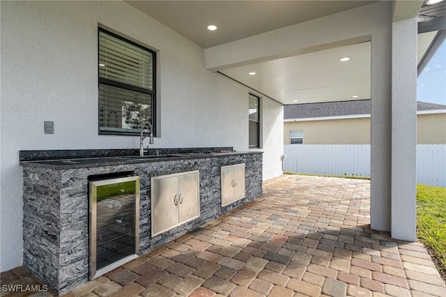 view of patio featuring sink, wine cooler, and exterior kitchen