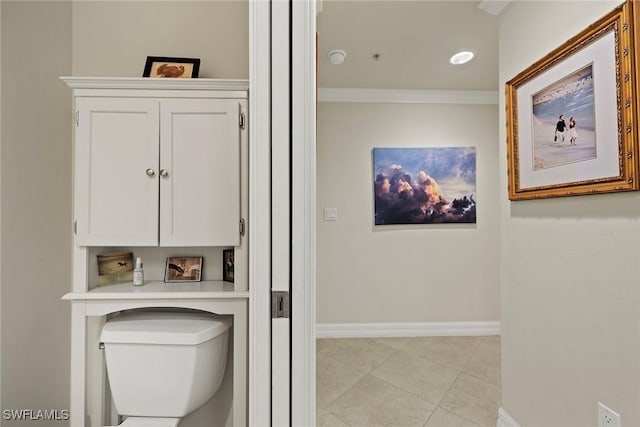 bathroom featuring tile patterned floors, crown molding, and toilet