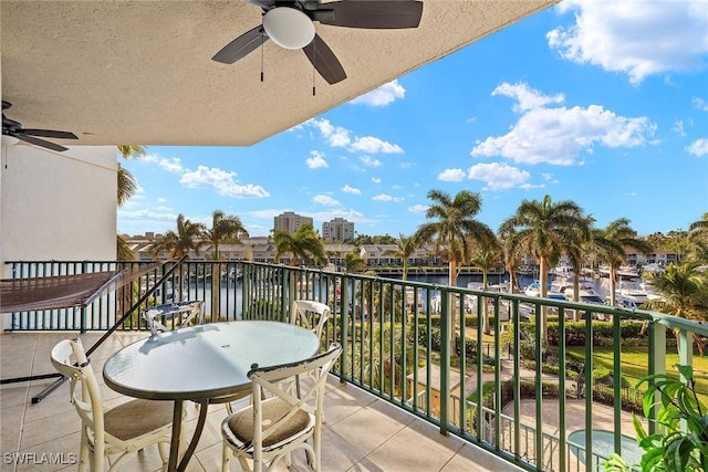 balcony with ceiling fan and a water view