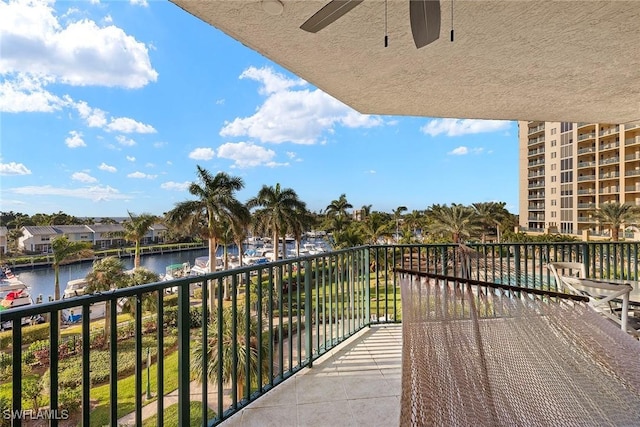 balcony with ceiling fan and a water view