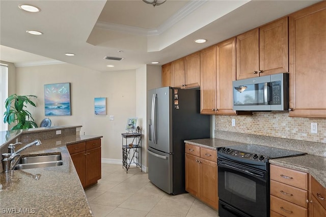 kitchen featuring a raised ceiling, crown molding, sink, dark stone countertops, and appliances with stainless steel finishes