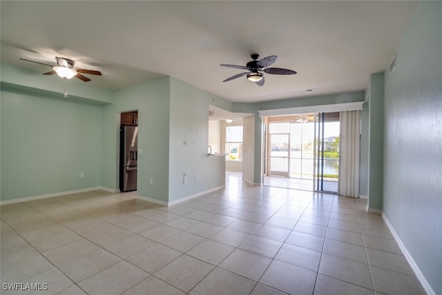 empty room with ceiling fan and light tile patterned flooring