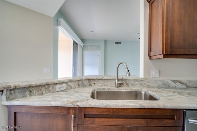 kitchen with light stone countertops and sink