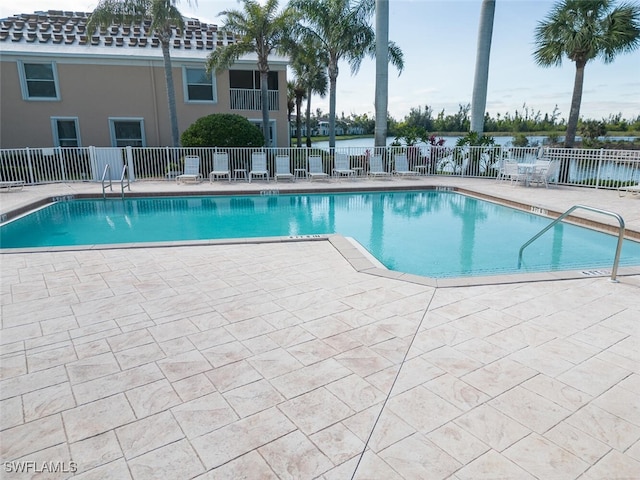 view of swimming pool featuring a patio area and a water view