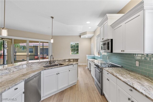 kitchen featuring pendant lighting, white cabinetry, sink, and stainless steel appliances