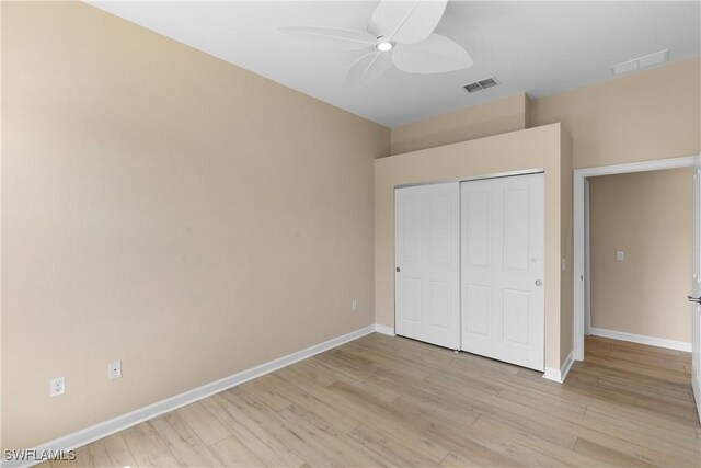 unfurnished bedroom with ceiling fan, light hardwood / wood-style flooring, and a closet