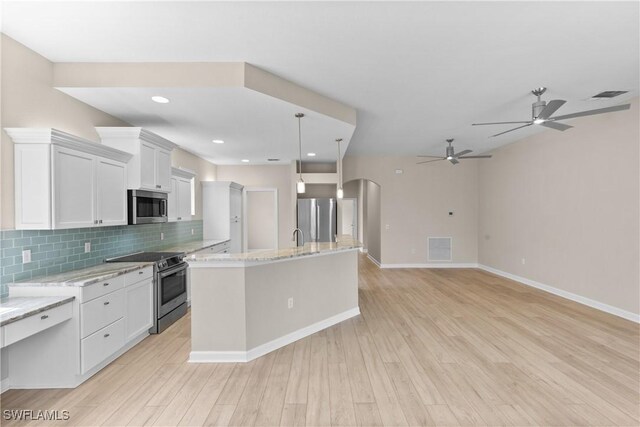 kitchen with pendant lighting, a kitchen island with sink, white cabinets, decorative backsplash, and stainless steel appliances