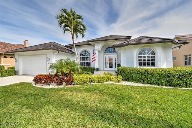 mediterranean / spanish-style house with a garage and a front lawn