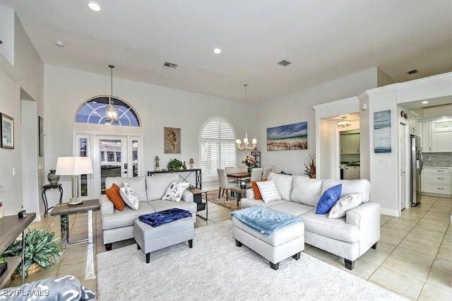 living room with washer / dryer, light tile patterned floors, and an inviting chandelier