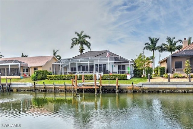 rear view of house with glass enclosure and a water view