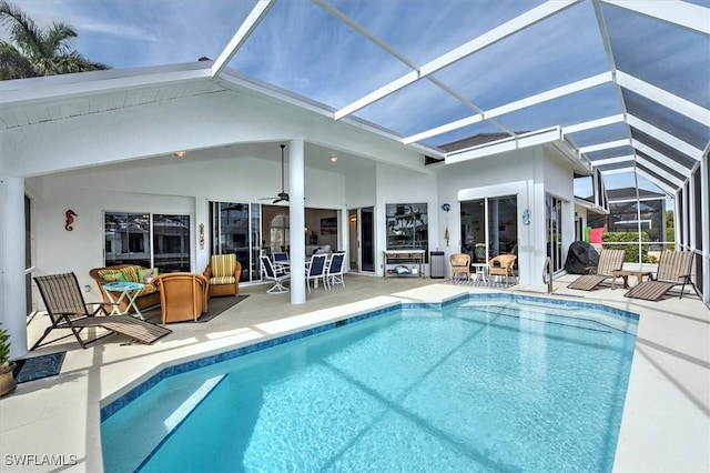 view of pool featuring glass enclosure, ceiling fan, and a patio