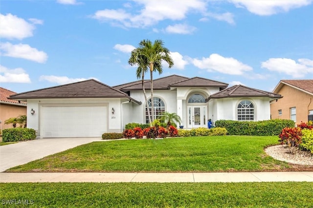 mediterranean / spanish-style house featuring a garage and a front lawn