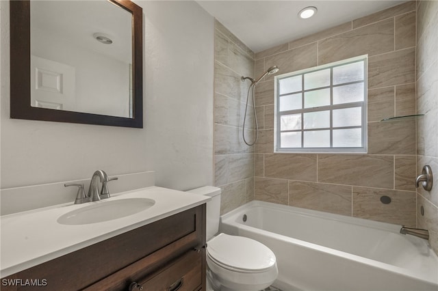 full bathroom featuring toilet, tiled shower / bath combo, and vanity