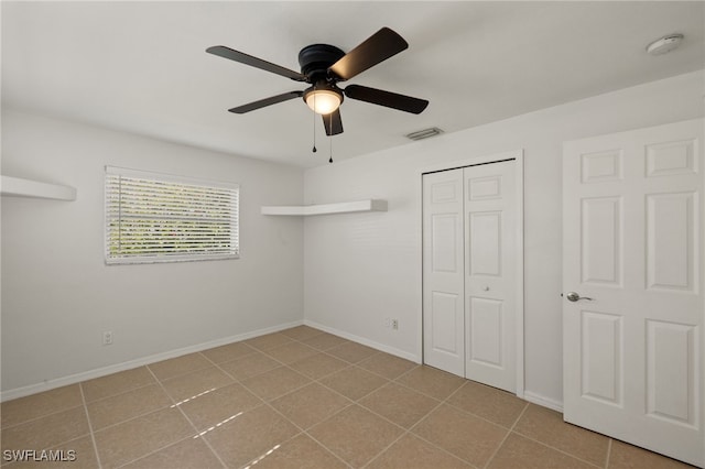 unfurnished bedroom featuring ceiling fan and a closet