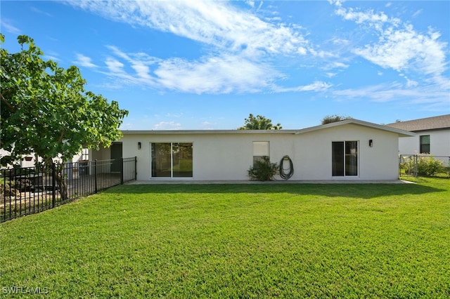 back of property featuring a lawn