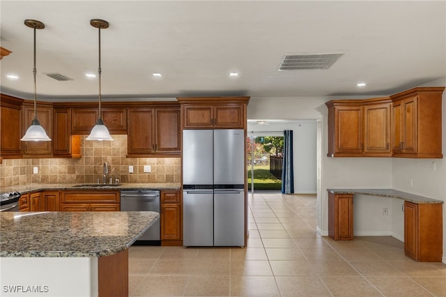 kitchen featuring stainless steel appliances, pendant lighting, decorative backsplash, sink, and stone countertops