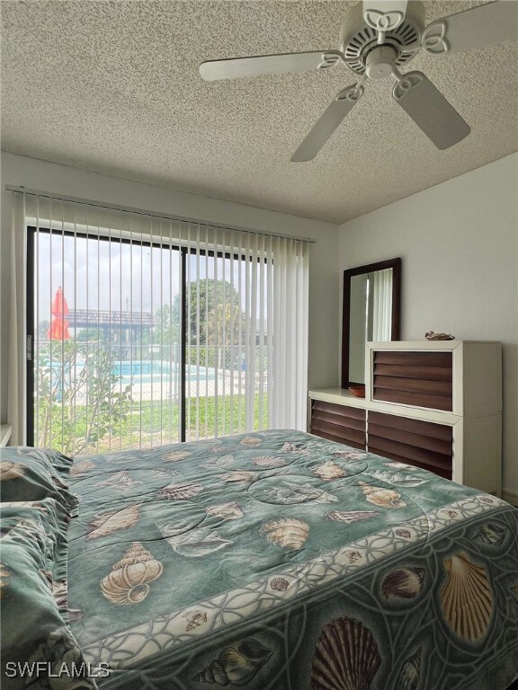 bedroom featuring a textured ceiling, ceiling fan, and access to exterior