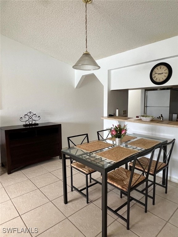 dining room with a textured ceiling and light tile patterned flooring