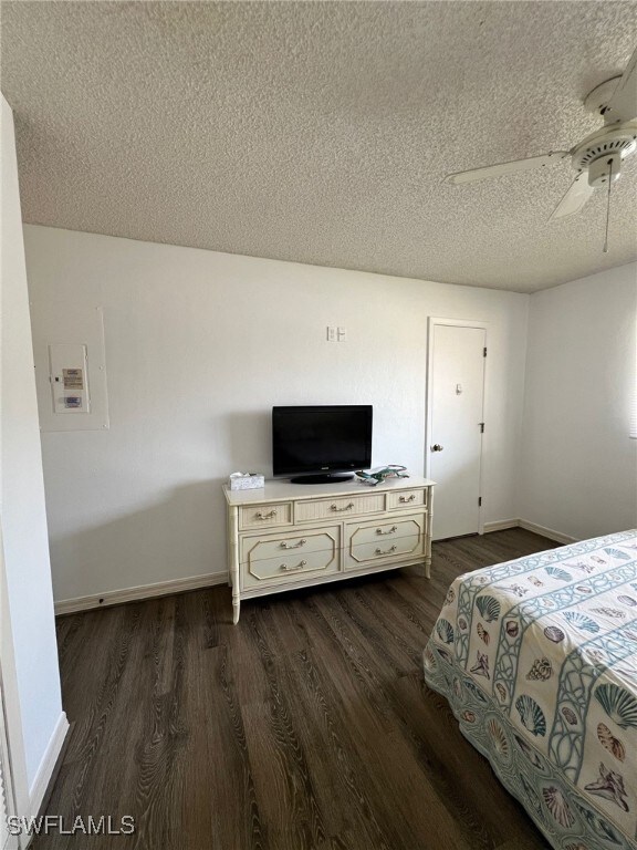 unfurnished bedroom featuring ceiling fan, dark hardwood / wood-style flooring, and a textured ceiling