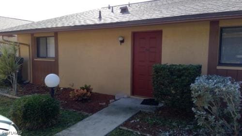 entrance to property featuring stucco siding