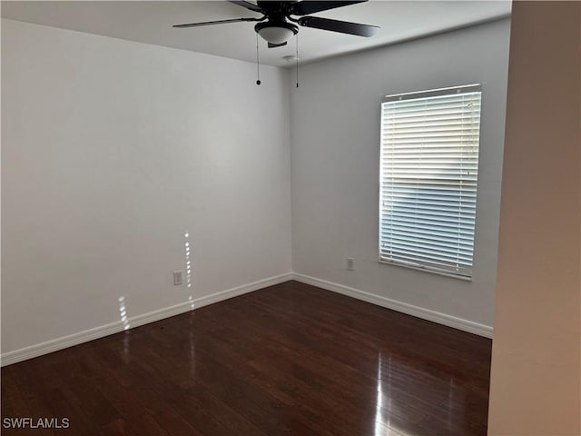 empty room with ceiling fan and dark hardwood / wood-style floors