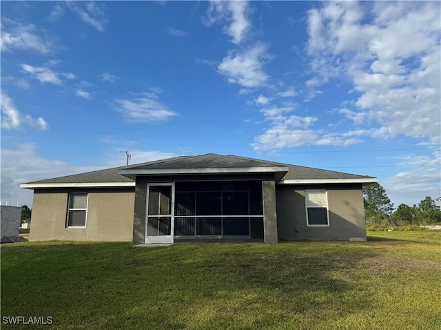 back of property featuring a yard and a sunroom