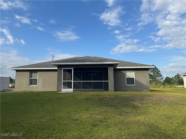 back of property with a yard and a sunroom