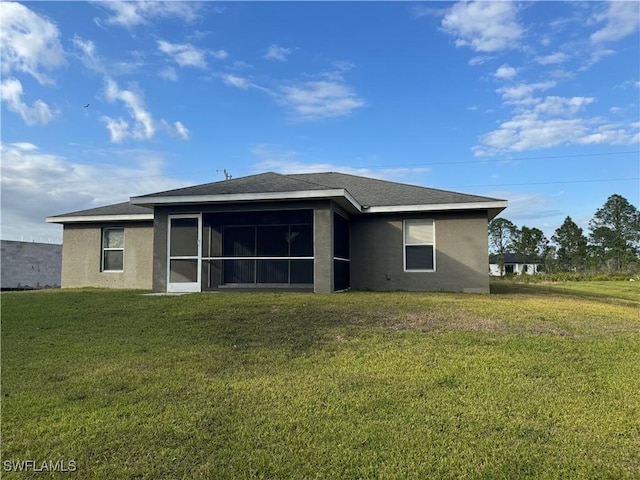 rear view of property with a lawn and a sunroom