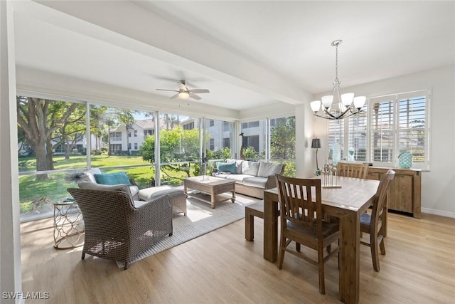 sunroom with ceiling fan with notable chandelier