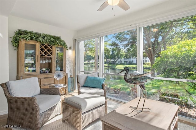 sunroom with a water view and ceiling fan