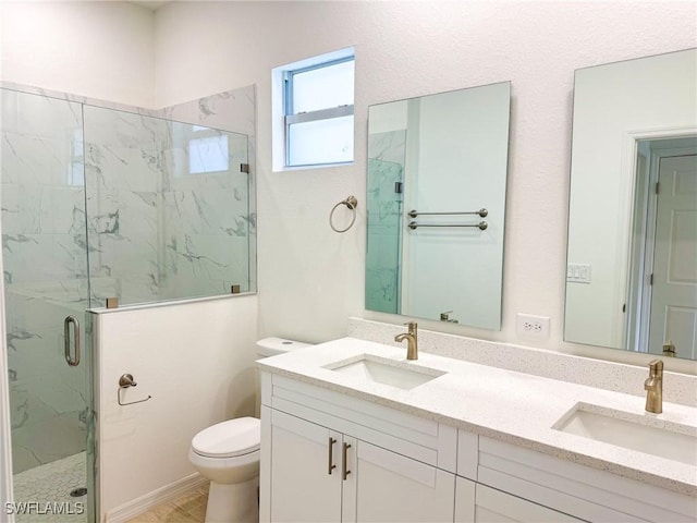 bathroom with vanity, toilet, and a shower with door