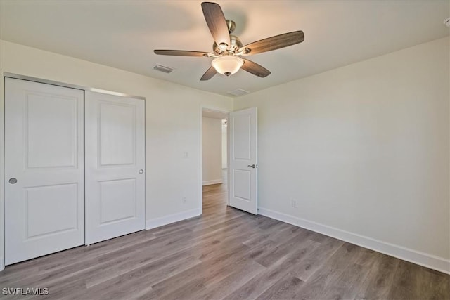 unfurnished bedroom with visible vents, baseboards, light wood-style floors, and a closet